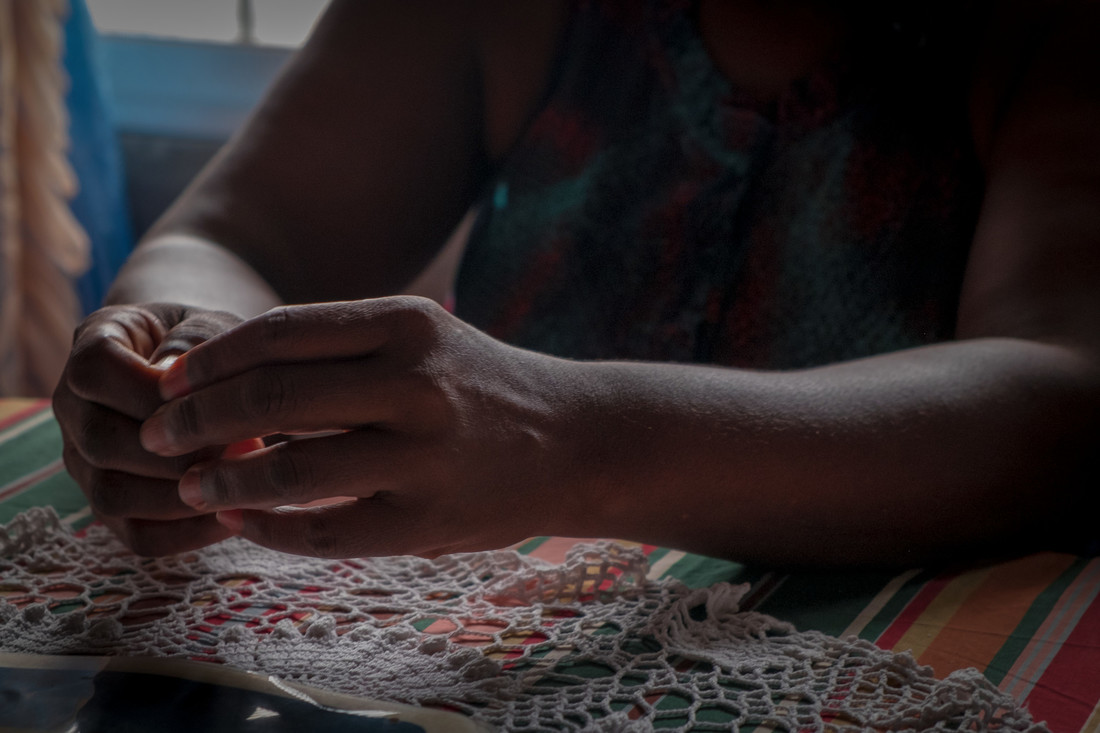 A close-up image of a woman's hands in shadow.